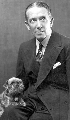 Gerald du Maurier, seated with a dog