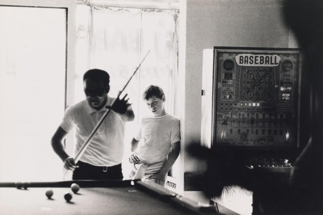 Boy watching a man play billiards, 1970