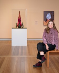 Serena Bentley sitting in the In Bloom exhibition