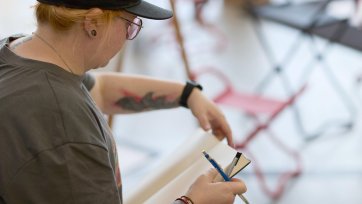 A woman with a pencil and drawing pad