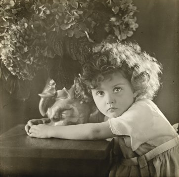 Young girl with elephant vase filled  with hydrangeas