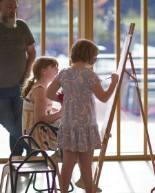 Two children drawing at an easel in the Gordon Darling Hall Two children drawing at an easel in the Gordon Darling Hall