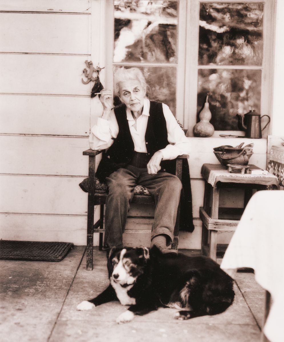 Nora Heysen with her dog sitting outside her home, Hunters Hill, Sydney