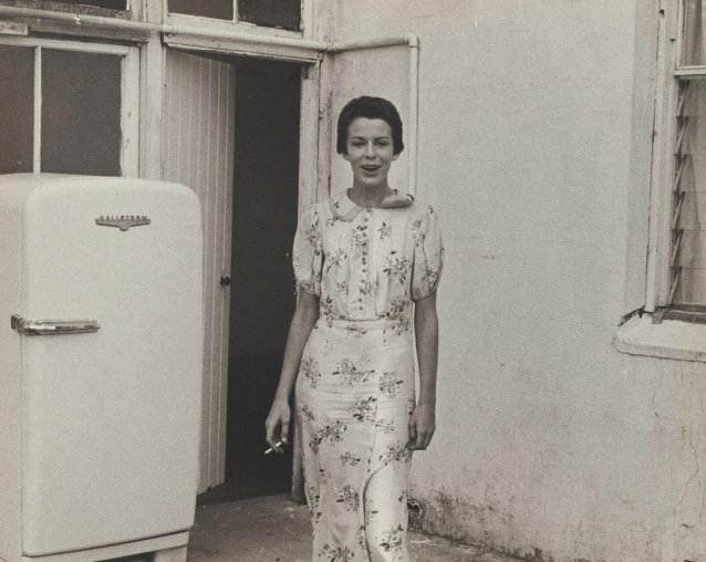 Lynn Gailey standing next to a refrigerator, 1976