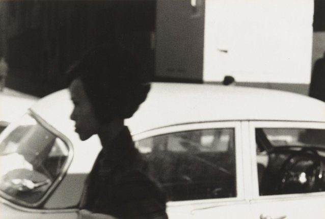 Young woman in front of parked car, 1970