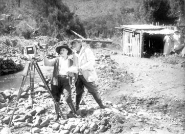 Louise Lovely and Wilton Welch setting up a camera on a rocky river bank