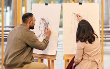 Two people drawing at easels Two people drawing at easels