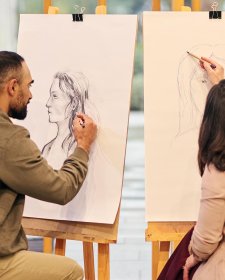 Two people drawing at easels Two people drawing at easels