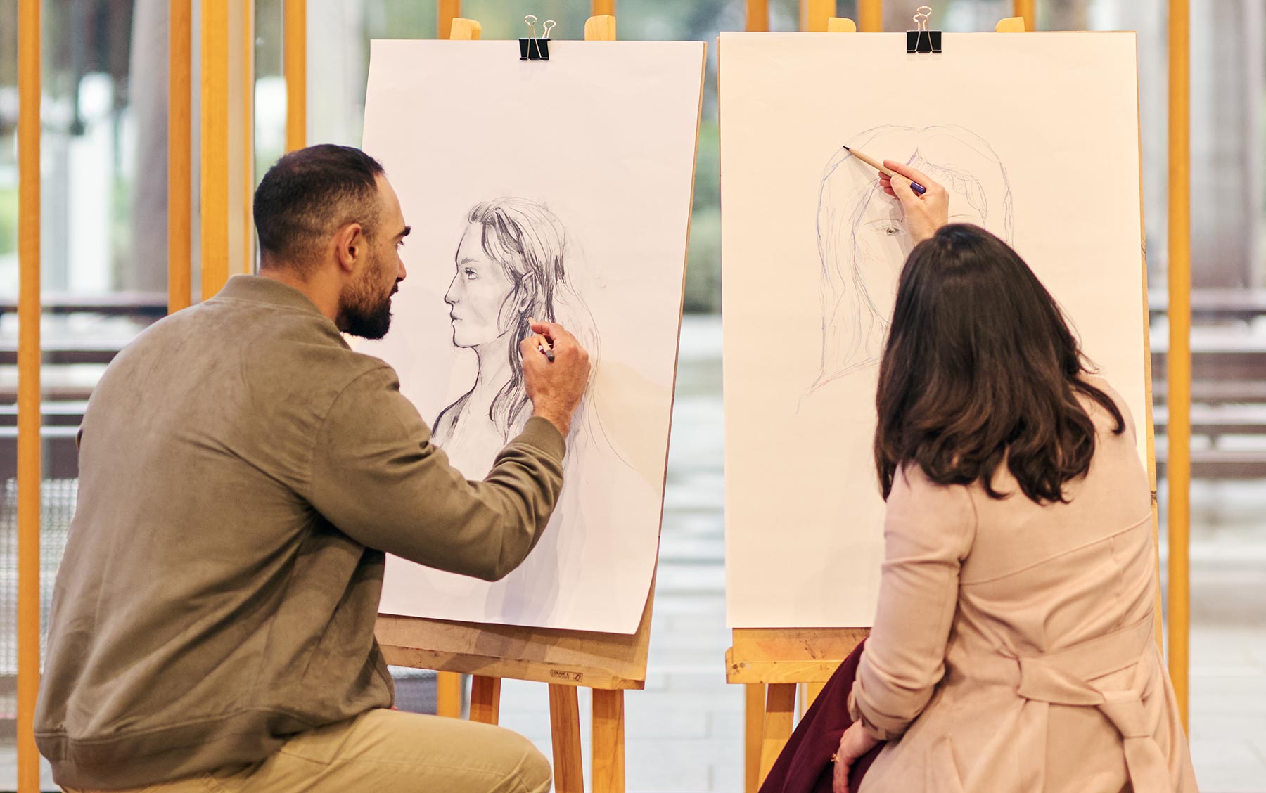 Two people drawing at easels