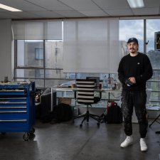 Abdul Abdullah in his studio with large windows overlooking a suburban street