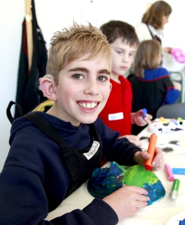 A hard of hearing student creating a mask in a theatre and making workshop