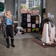 Tarryn Gill standing in her studio next to a sculpture on a white plinth