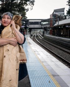 Latai Taumoepeau holding a blanket to her body while standing on the platform at a train station