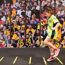 A child running in front of a large audience