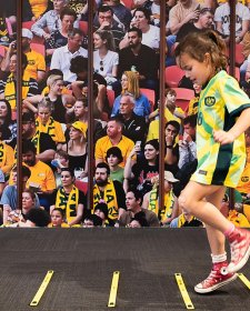 A child running in front of a large audience