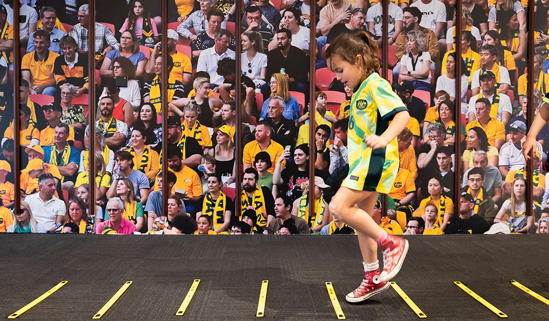 A child running in front of a large audience