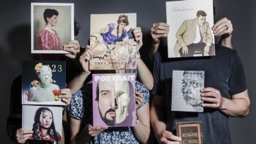 Hands holding a series of books in front of people, hiding their faces