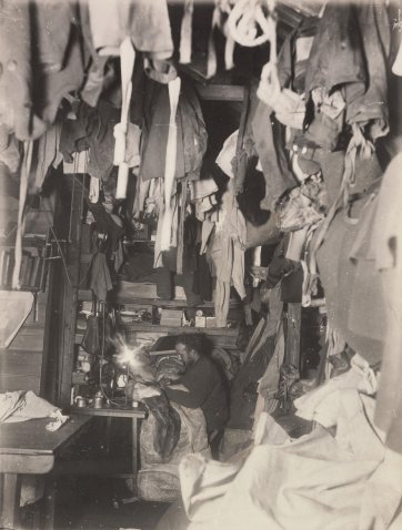 A corner of the hut, Bage mending his sleeping-bag, c.1913 Frank Hurley