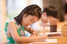 A child drawing at a wooden table A child drawing at a wooden table