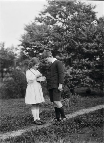 Boy and Girl looking at box in girl's hand by Ruth Hollick