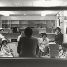 Doctor, back to glass window, nurses meeting, 1979 Carol Jerrems