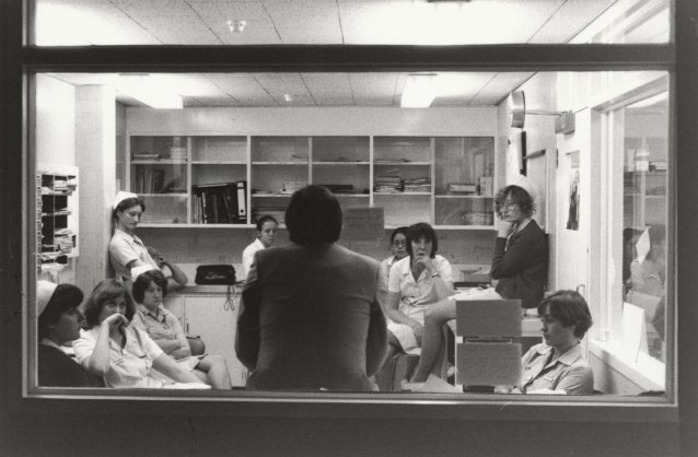 Doctor, back to glass window, nurses meeting, 1979
