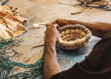Anindilyakwa artist Maicie Lalara weaving baskets with ghost nets and pandanus, 2019