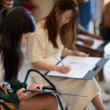 People drawing on paper notepads People drawing on paper notepads