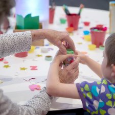 Grandparents and children at a table with craft activities Grandparents and children at a table with craft activities