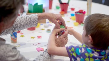 Grandparents and children at a table with craft activities
