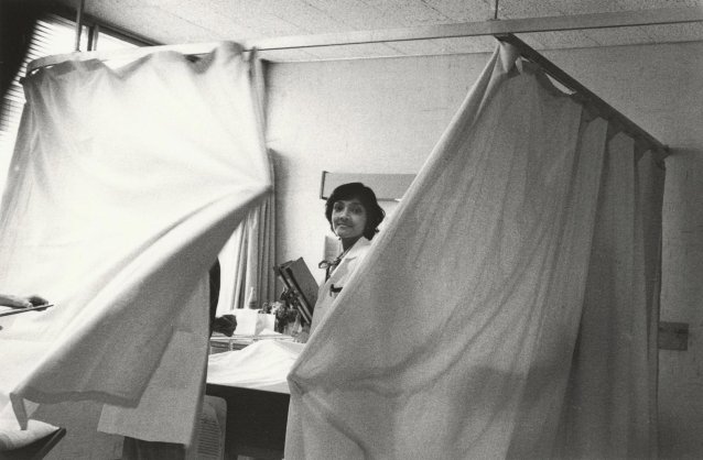 Doctor/Nurse pulling curtain around bed, 1979
