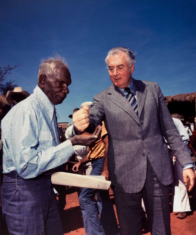 Prime Minister Gough Whitlam pours soil into the hand of traditional land owner Vincent Lingiari