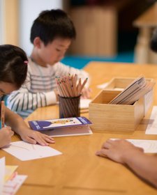 Children sitting at a table and drawing