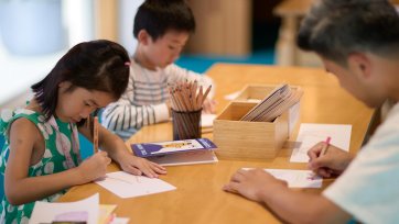 Children sitting at a table and drawing