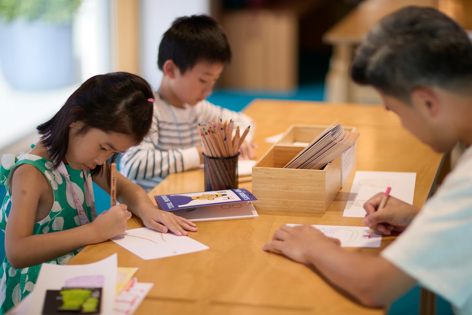 Children sitting at a table and drawing