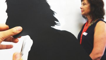 Cutting out a paper silhouette in the shape of a head