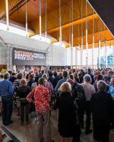 A large crowd of people in the Gordon Darling Hall for the National Photographic Portrait Prize launch in 2019