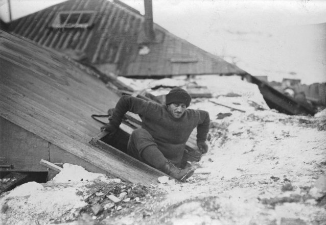 Mertz emerging from trap-door in roof, Australasian Antarctic Expedition, 1911-1914