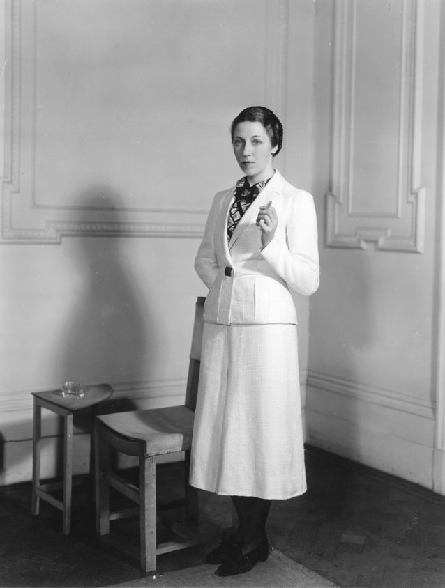 Amy Johnson wearing a woollen suit from the collection of flight clothes designed by Madame Schiaparelli for her solo flight from London to Cape Town, 1938