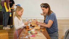 Parents and children at a table with craft activities Parents and children at a table with craft activities